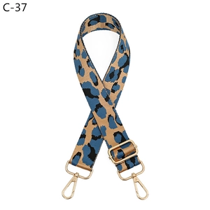 Detail of adjustable leopard print bag strap with blue and brown patterns and gold buckle