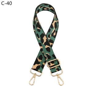 Macro shot of adjustable leopard print bag strap in green and black with gold hardware