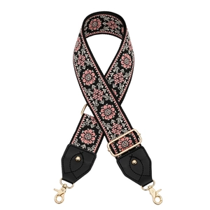 Detail of bohemian embroidered wide shoulder strap with floral patterns and gold metal clasps