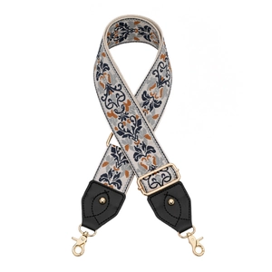 Détail d'une bandoulière tressée rétro avec motif floral et attaches dorées