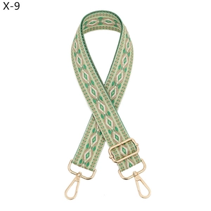 Close-up of ethnic geometric jacquard bag strap with gold metal hooks and adjuster