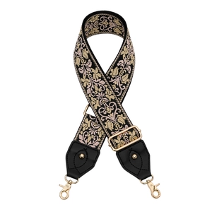 Détail de la bandoulière en jacquard fleuri avec crochets dorés et embouts en cuir noir