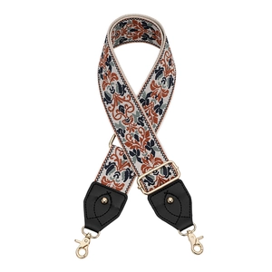 Détail d'une bandoulière brodée bohème avec mousquetons dorés et boucle de réglage en métal