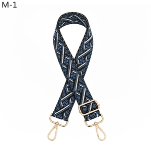 Close-up of ethnic woven bag strap with blue floral pattern and gold metal hooks