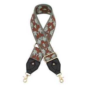 Détail de la bandoulière jacquard à fleurs vintage avec mousquetons métalliques dorés