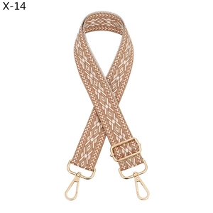Close-up of geometric jacquard shoulder strap with gold metal swivel hooks and buckles