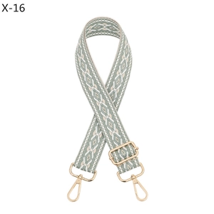 Detail of adjustable woven bag strap with morandi green geometric pattern and gold clips