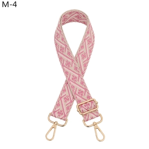 Detail of adjustable ethnic geometric pattern bag strap with light gold metal lobster clasps