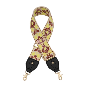 Détail de bandoulière large brodée avec boucles dorées et finitions en cuir noir chic