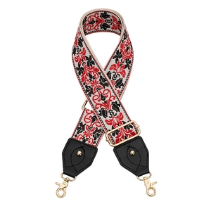 Détail d'une bandoulière brodée ethnique avec motif floral et crochets dorés