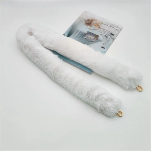 Close-up of white plush faux fur shoulder strap with golden metal spring buckles