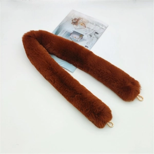 Detail of dark brown faux fur bag strap with gold metal hooks on white surface