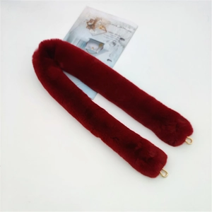 Detail of burgundy plush faux fur shoulder strap with golden metal D-rings for handbags