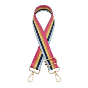 Detail view of adjustable rainbow striped nylon bag strap with gold metal lobster clasps