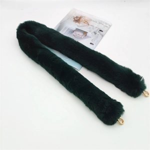 Close-up of fluffy faux fur bag strap in dark green with golden metal lobster clasps