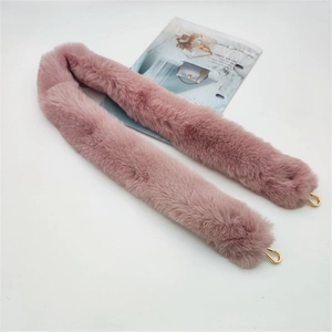 Macro shot of dusty pink faux rabbit fur shoulder strap with golden metal hooks