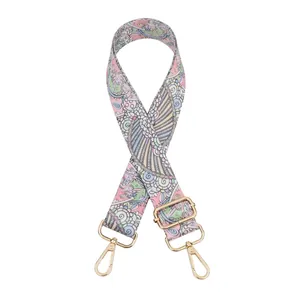 Détail d'une bandoulière ajustable à motif paisley avec boucles en métal doré