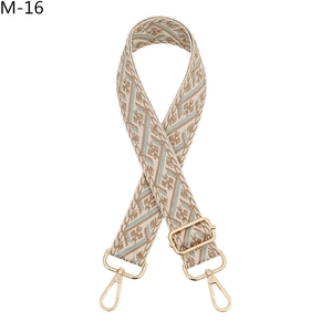 Detailed view of bohemian style woven bag strap with geometric patterns and gold lobster clasps