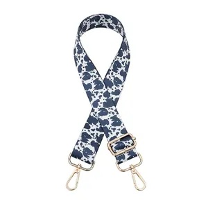 Detail of adjustable cow print bag strap with golden metal hardware and swivel hooks