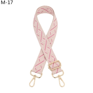 Close-up of pink and white geometric jacquard bag strap with gold metal lobster clasps