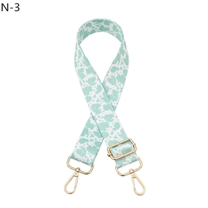 Detail of mint green cow print replacement bag strap with golden metal lobster hooks
