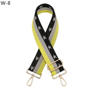 Detail of adjustable star pattern bag strap with golden metal hooks and jacquard weave