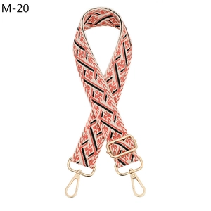 Close-up of ethnic jacquard purse strap with gold metal hooks and adjustable buckle