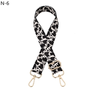 Detail of adjustable cow print bag strap with durable golden metal lobster clasps