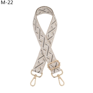 Close-up of ethnic style jacquard bag strap with geometric patterns and gold metal hooks