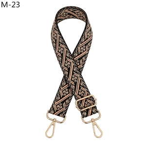 Close-up of ethnic geometric jacquard bag strap with gold metal lobster clasps