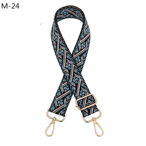 Detailed view of ethnic jacquard strap with navy floral pattern and gold metal lobster clips