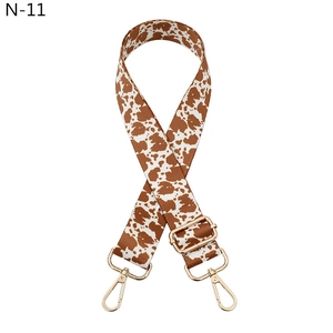 Adjustable brown cow print bag strap with golden metal lobster clasps for shoulder bags