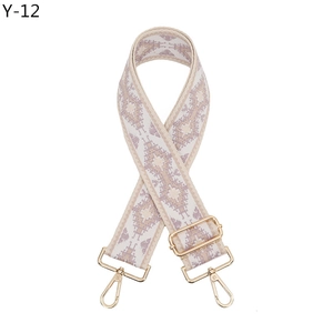Close-up of ethnic style woven bag strap with geometric diamond patterns and gold buckles