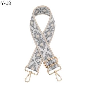 Detail of adjustable vintage woven bag strap with ethnic patterns and gold metal hooks