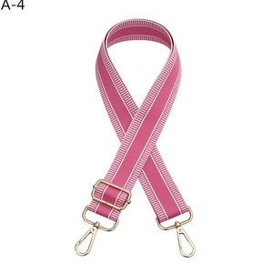 Detail view of adjustable pink and white striped nylon bag strap with gold metal hooks