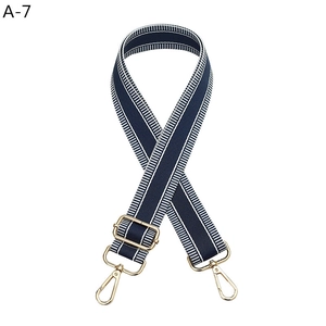 Detail of adjustable navy and white striped bag strap with premium gold metal hooks