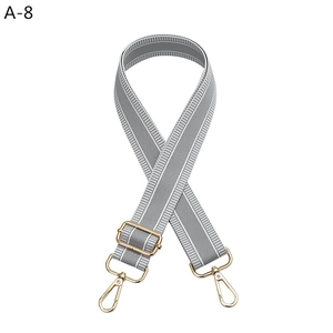 Detail of adjustable grey and white striped bag strap with gold lobster clasps