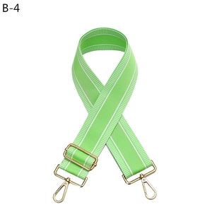 Adjustable green shoulder strap with white stripes and gold metal hardware for bags