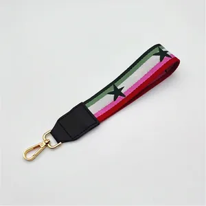 Detail of colorful striped handbag strap with black stars and gold spring hook
