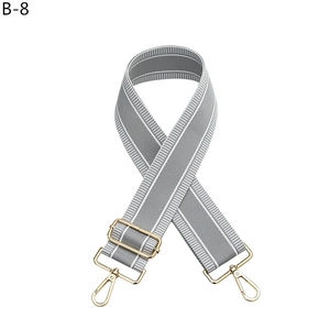 Adjustable wide grey fabric shoulder strap with white stripes and gold metal hooks