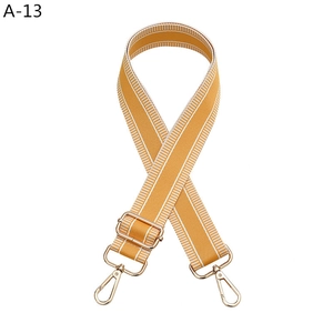 Detail of adjustable orange and white striped bag strap with gold metal buckle