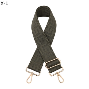 Macro detail of olive green woven bag strap with golden hardware and Greek key pattern