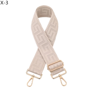 Detail of beige geometric jacquard strap with gold adjustable buckle and swivel hooks