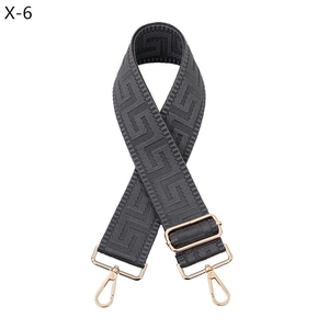 Detail showing grey Greek key pattern webbed bag strap with gold metal hardware