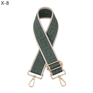Detailed view of dark green jacquard wide bag strap with golden metal lobster clasps