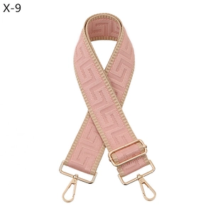 Detail of pink and beige geometric jacquard strap with rose gold metal hardware and hook