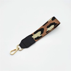 Leopard print strap with gold lobster clasp for handbags and keychains on white background