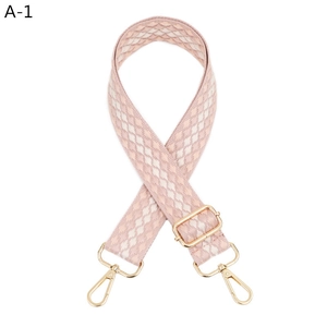 Detail of adjustable pink and cream woven shoulder strap with gold lobster clasps