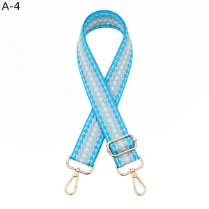Detail of blue and silver geometric woven shoulder strap with gold-tone metal hooks