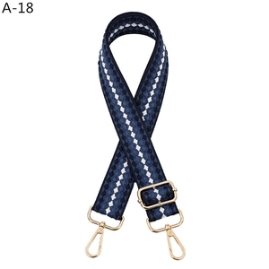 Detail of adjustable blue and white woven guitar strap with gold metal lobster clasps